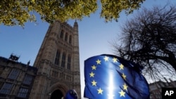 FILE - The sun shines through European Union flags tied to railings outside parliament in London, Jan. 22, 2019. 