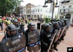 FILE - Virginia State Police cordon off an area around the site where a car ran into a group of protesters after a white nationalist rally in Charlottesville, Va., Aug. 12, 2017.