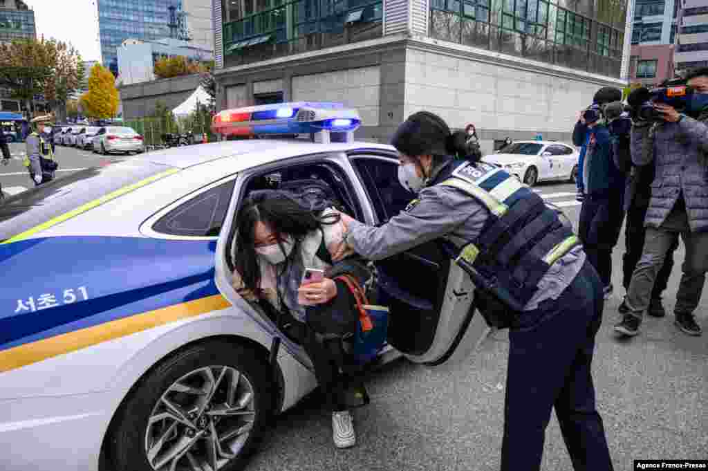 A student arrives with police to sit for the yearly university entrance exams outside the Ehwa Girls Foreign Language High School in Seoul, South Korea.