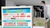 日本成田国际机场的工作人员在调整体温监测仪以测试从中国武汉和其他城市抵达的旅客健康状况。（2020年1月23日）