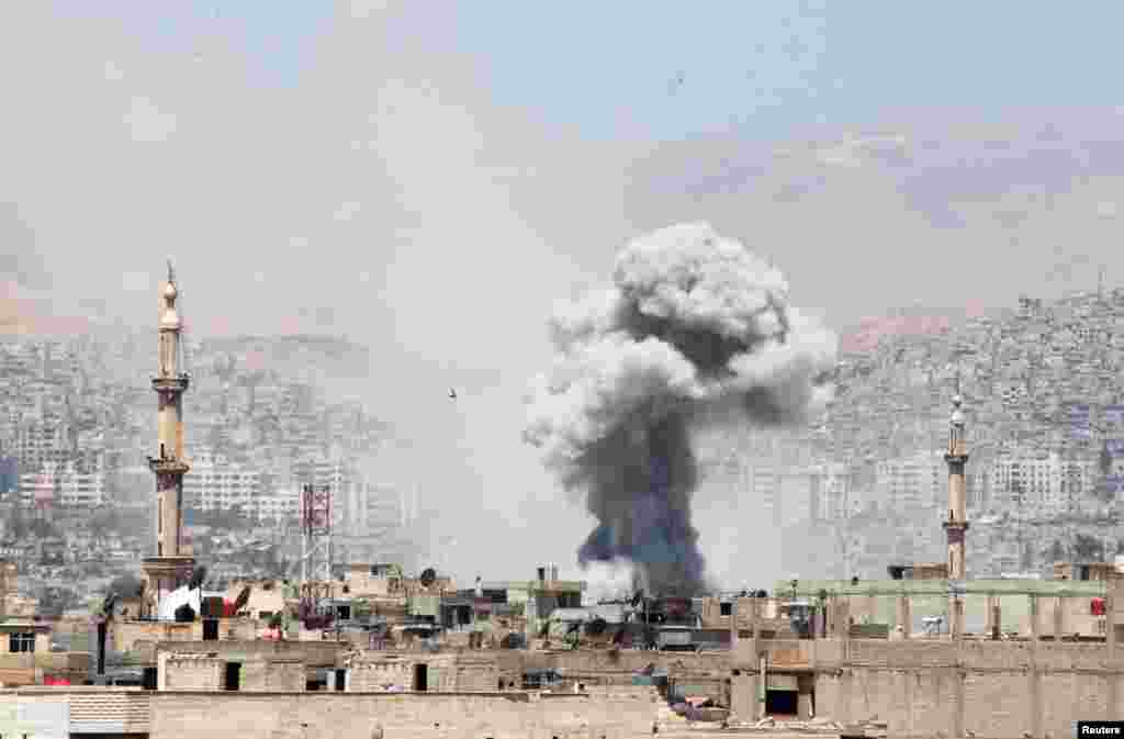 Smoke rises after what activists said was due to airstrikes by forces loyal to Syria&#39;s President Bashar al-Assad in Erbeen in the eastern Damascus suburb of Ghouta.