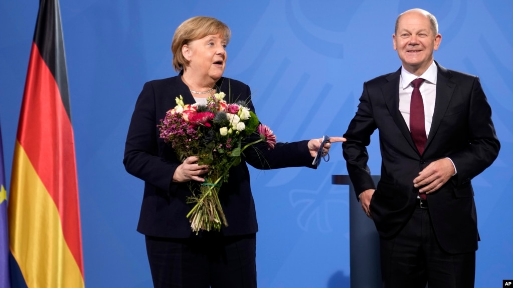 New elected German Chancellor Olaf Scholz, right, has given flowers to former Chancellor Angela Merkel during a handover ceremony in the chancellery in Berlin, Wednesday, Dec. 8, 2021. (Photo/Markus Schreiber)