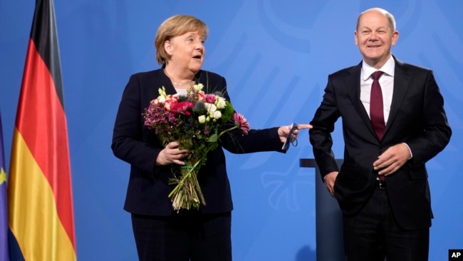 New elected German Chancellor Olaf Scholz, right, has given flowers to former Chancellor Angela Merkel during a handover ceremony in the chancellery in Berlin, Wednesday, Dec. 8, 2021. (Photo/Markus Schreiber)