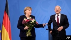 New elected German Chancellor Olaf Scholz, right, has given flowers to former Chancellor Angela Merkel during a handover ceremony in the chancellery in Berlin, Wednesday, Dec. 8, 2021. (Photo/Markus Schreiber)