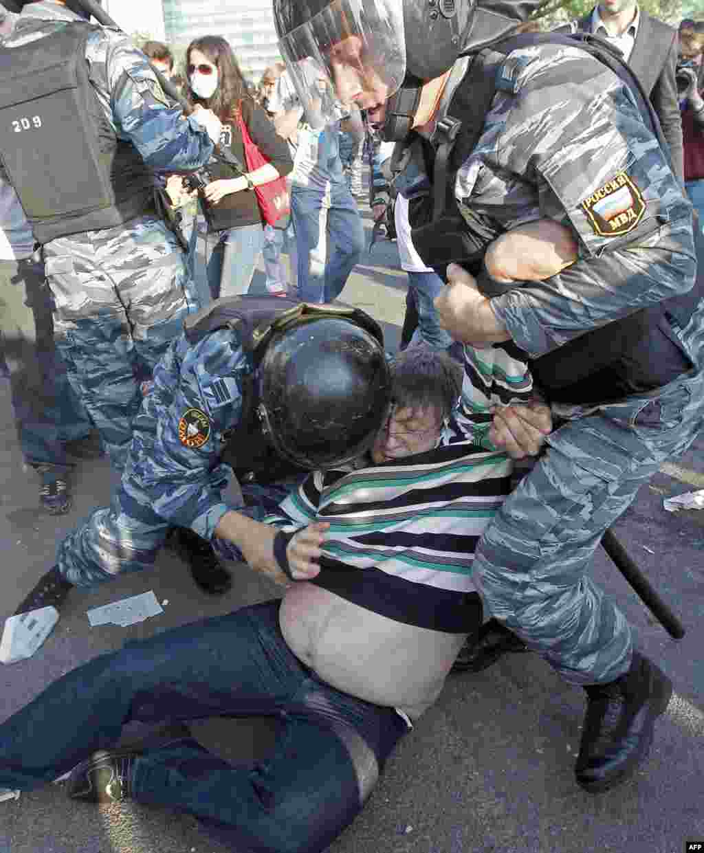 Russian riot policemen detain an opposition protester in downtown Moscow on Sunday, May 6, 2012. Riot police in Moscow have begun arresting protesters who were trying to reach the Kremlin in a demonstration on the eve of Vladimir Putin's inauguration as p