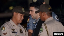 FILE - Philippine Bureau of Corrections personnel escort U.S. Marine Lance Corporal Joseph Scott Pemberton (C), after he was found guilty by trial court of killing Jennifer Laude, a transgender woman, upon arrival in a detention facility at Camp Aguinaldo