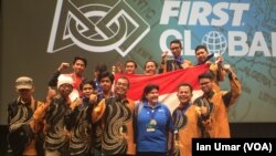 Tim Robotik Indonesia dari Madrasah Aliyah TechnoNatura, Depok, berpose dengan bendera Indonesia di panggung.