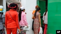 Cambodian garment workers return to a factory after their lunch break in Phnom Penh, Cambodia Thursday, March 12, 2015.