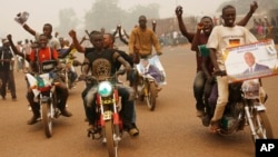 Supporters of presidential candidate Faustin Archange Touadera rally during a sandstorm in the streets of Bangui, Central African Republic, Feb. 12, 2016.
