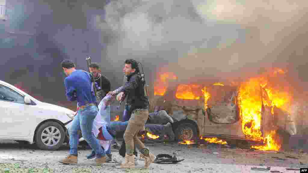 A handout picture released by the official Syrian Arab News Agency (SANA) shows Syrians carrying an injured man after a powerful car bomb exploded near the headquarters of Syria's ruling Ba'ath party in the center of Damascus, February 21, 2013.