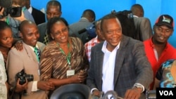 Uhuru Kenyatta oo codkiisa dhiibanaya dad taageersanna ay ku wareegsan yihiin.