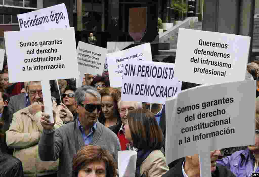 Journalist hold placards reading 'We are guarantors of the constitutional right to information' and 'There is no democracy without journalism' during a demonstration to mark the World Press Freedom Day on May 03, 2012 in Madrid.