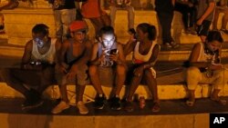 Jóvenes cubanos usan el wifi de un hotel cercano cinco estrellas en La Habana, Cuba.