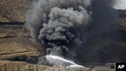 Firefighters battle a huge fire after several explosions were set off at the army's First Armored Division headquarters in Sanaa, Yemen, Oct. 18. 2012. 