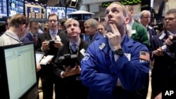 Specialist Patrick Kenny, foreground right, works his post on the floor of the New York Stock Exchange, March 1, 2013.