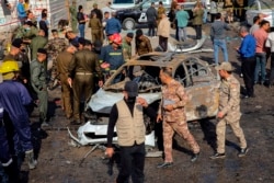 FILE - Iraqi security forces inspect the site of an explosion in Basra, Iraq, Dec. 7, 2021.