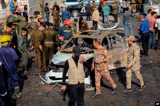 FILE - Iraqi security forces inspect the site of an explosion in Basra, Iraq, Dec. 7, 2021.