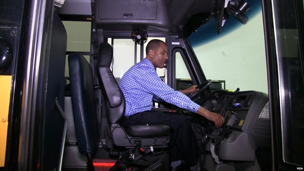 Tashitaa Tufaa drives one of his company's largest school buses, which seats 70 pupils, in Fridley, Minnesota, Aug. 9, 2017. Tufaa's company owns nearly 300 buses. (Photo: Abdi Mohamud for VOA)