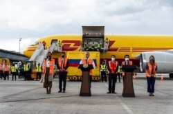 Presiden Kolombia Ivan Duque (tengah) menyampaikan pidato pada saat wadah berpendingin yang berisi 50.000 dosis vaksin COVID-19 produksi Pfizer tiba di bandara internasional El Dorado, Bogota, 15 Februari 2021. (Foto: Efrain HERRERA / Colombian Presidency / AFP)