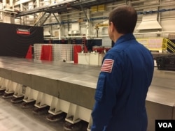 Astronaut Rex Walheim looking at the 'barrel' at Ingersoll Machine Tools in Rockford, Illinois. (K. Farabaugh/VOA)