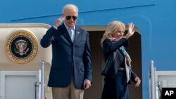 Prezidan Jose Biden salye milite yo pandan premye dam Jill Biden di babay anvan yo monte abo Air Force One, avyon prezidansyel la, 28 Oct. 2021.