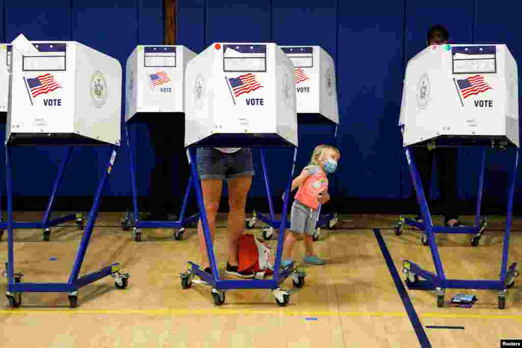 People fill out ballots during voting in the New York mayoral primary election at a polling site in the Brooklyn borough.