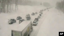 In this image taken from video from a Caltrans remote video traffic camera, traffic is stopped along a snow covered Interstate 80 at Donner Summit, Calif., Dec. 23, 2021.