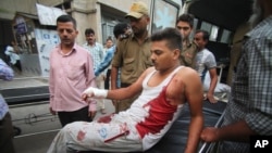 An injured Indian civilian of cross border firing gets down from an ambulance at the Government Medical College hospital in Jammu, India, Friday, Aug. 28, 2015.