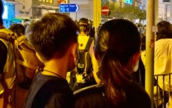 香港市民颜小姐抱着6岁的儿子8月31日晚在太子地铁站出口献花，悼念8-31事件死难者 (美国之音/汤惠芸）