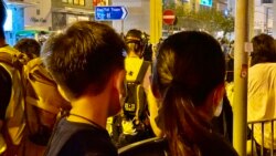 香港市民顏小姐抱著6歲的兒子8月31日晚在太子地鐵站出口獻花，悼念8-31事件死難者。(美國之音湯惠芸攝）