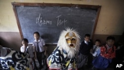 A Tibetan mask dancer wearing a traditional costume prepares in a classroom of a Tibetan school before participating in an event to mark the Dalai Lama's birthday, in Kathmandu July 6, 2011
