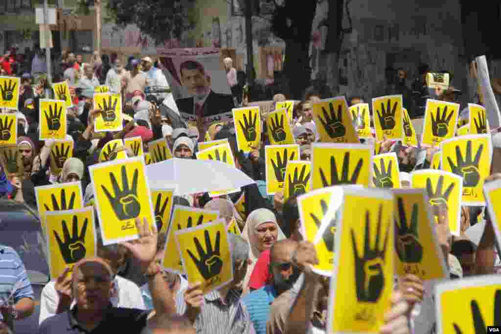 Demonstrators hold up four fingers, a symbol of their solidarity with the the destroyed sit-in protest known as Rabaa, which means four or fourth in Arabic, Cairo, August 23, 2013. (H. Elrasam for VOA)