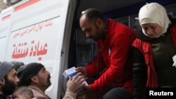 Relawan Bulan Sabit Merah Suriah memberikan bantuan obat-obatan kepada warga sipil di Ghouta, Suriah, 5 Maret 2018.
