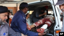 Pakistani volunteers carry an injured person who arrived from Mardan, at a local hospital in Peshawar, Pakistan, Sept. 2, 2016.