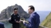 韩国总统李明博（右）2012年8月10日访问被韩国称之“独岛”而被日本称之为“竹岛” 的时候与韩国警官谈话