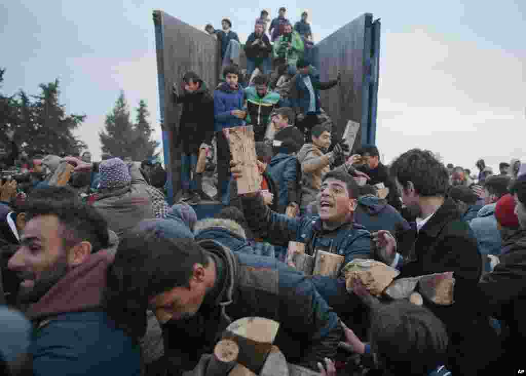 Migrants mob a truck bringing donated firewood at the northern Greek border station of Idomeni.