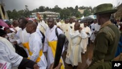 FILE - A Kenyan soldier directs Catholic priests as they queue after dawn to attend a Holy Mass to be given by Pope Francis at the campus of the University of Nairobi in Kenya Thursday, Nov. 26, 2015.