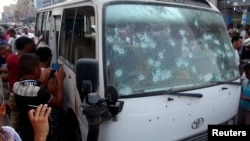 Cư dân vây quanh chiếc xe chở khách bị những kẻ vũ trang tấn công tại Aden, ngày 15/6/2014. 