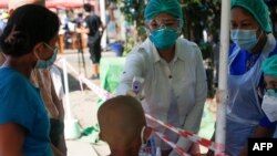 ရန်ကုန်မြို့ရှိ ရပ်ကွက်တခုအတွင်းတွင် အိမ်တိုင်ယာရောက် ကျန်းမာရေးစစ်ဆေးပေးနေတဲ့ ကျန်းမာရေးဝန်ထမ်းများ။ (မေ ၁၆၊ ၂၀၂၀)