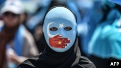 資料照：一名戴著面具的示威者在中國駐伊斯坦布爾領事館前抗議中國的新疆少數民族政策。 （2018年7月5日）