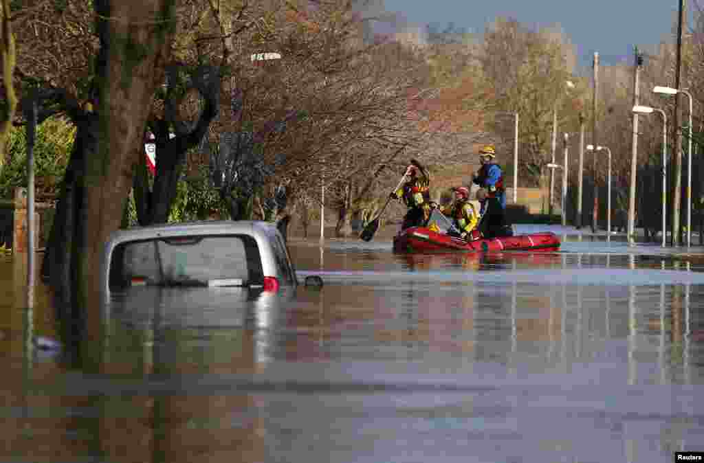 Members of the emergency services rescue local residents by boat from a flooded residential street in Carlisle, Britain.