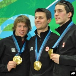Mathieu Giroux, Lucas Makowsky, and Denny Morrison of Canada show off their gold medals in team pursuit speedskating in Vancouver, Canada, 27 Feb 2010