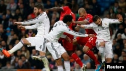 Liverpool and Real Madrid players jump for a ball during their Champions League Group B soccer match in Madrid November 4, 2014. 