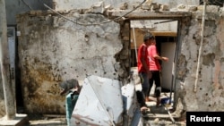 People inspect a damaged house after a suicide bomb attack in Baghdad's mainly Shi'ite district of Sadr City, Iraq, May 30, 2016. 