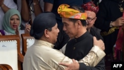 Presiden Jokowi (kanan) memeluk kandidat presiden, Prabowo Subianto, dalam deklarasi damai untuk kampanye pemilu di Monas, Jakarta, 23 September 2018 (foto: Adek Berry/AFP)