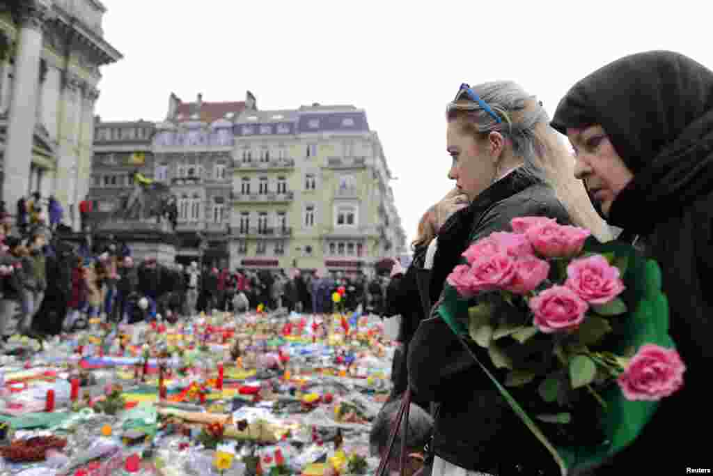 People observe a minute of silence at a street memorial to victims of Tuesdays's bombings in Brussels, Belgium, March 24, 2016. 