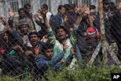 Migrants, most of them from Pakistan, protest against the EU- Turkey deal about migration inside the entrance of Moria camp in the Greek island of Lesbos on Tuesday, April 5, 2016.