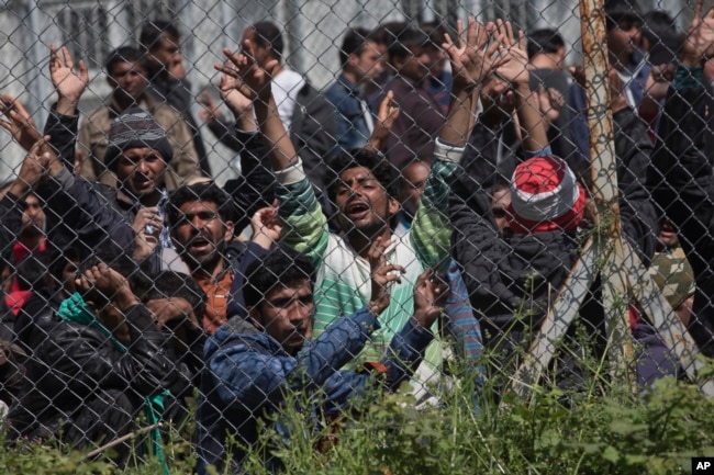 FILE - Migrants, most of them from Pakistan, protest against the EU-Turkey deal about migration inside the entrance of Moria camp in the Greek island of Lesbos, April 5, 2016.
