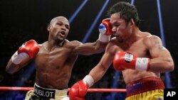 Floyd Mayweather Jr., left, hits Manny Pacquiao, from the Philippines, during their welterweight title fight in Las Vegas, Nevada, May 2, 2015. (AP Photo/Isaac Brekken) 