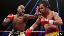 Floyd Mayweather Jr., left, hits Manny Pacquiao, from the Philippines, during their welterweight title fight in Las Vegas, Nevada, May 2, 2015.